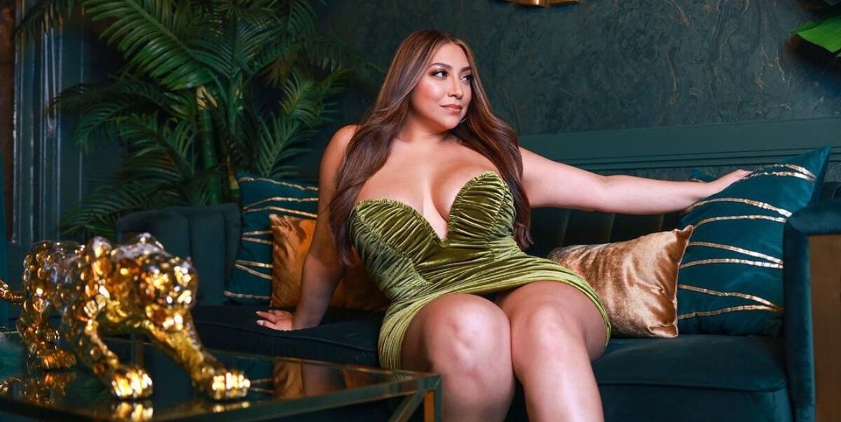 Lady wearing green dress relaxing on couch.