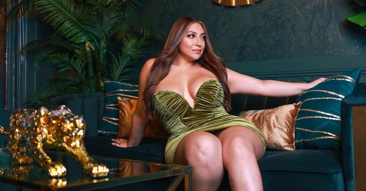 Lady wearing green dress relaxing on couch.